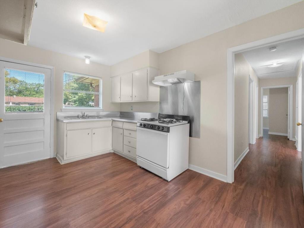 403 Rolando Drive Garland, TX 75040 - Photo 22 of 25 a kitchen with wooden floors and white appliances