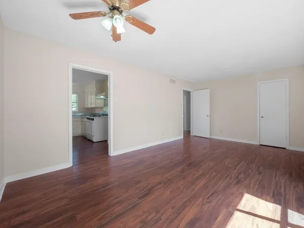 a view of a room with wooden floor and a ceiling fan