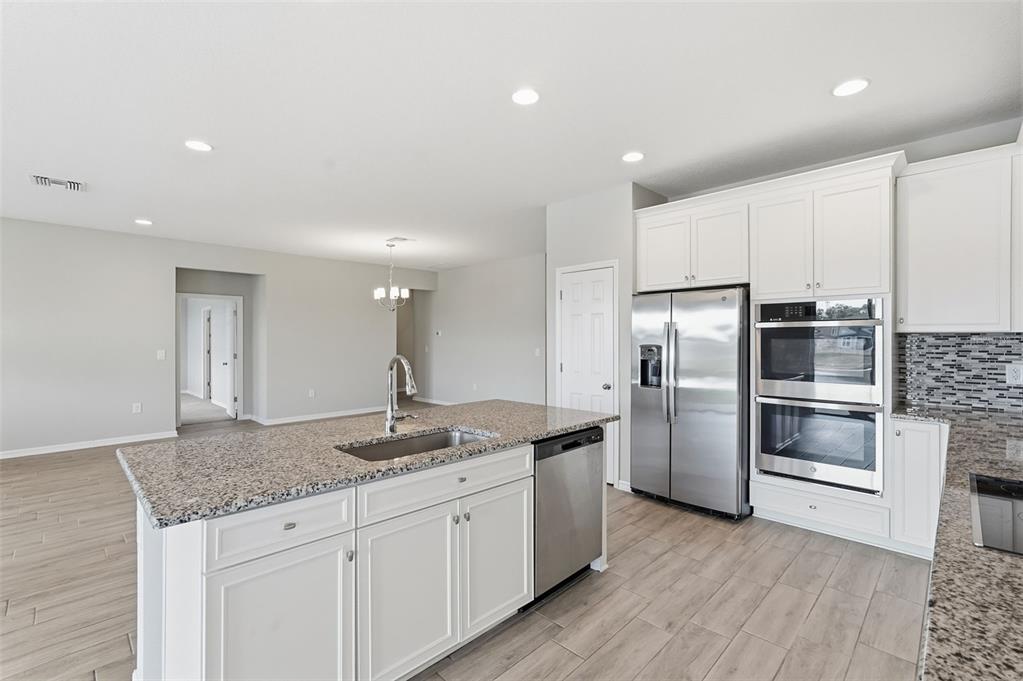 17618 Cortes Creek Boulevard Spring Hill, FL 34610 - Photo 13 of 40 a kitchen with stainless steel appliances granite countertop a refrigerator a sink a stove and oven