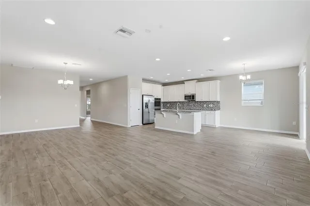 a view of kitchen with kitchen island wooden floor center island and appliances
