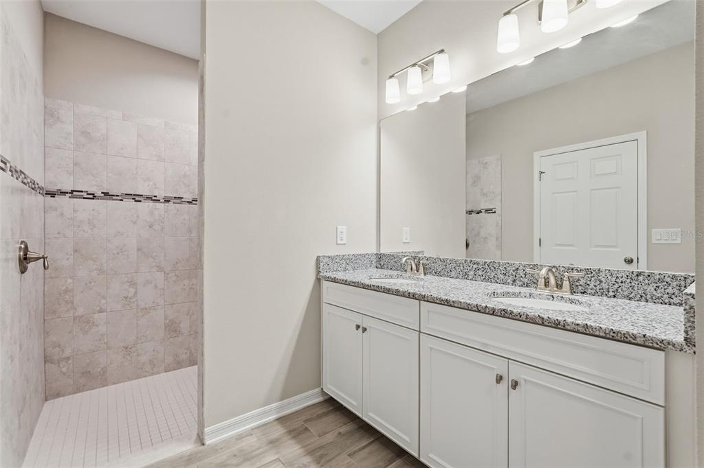 17618 Cortes Creek Boulevard Spring Hill, FL 34610 - Photo 26 of 40 a bathroom with a granite countertop sink and a mirror