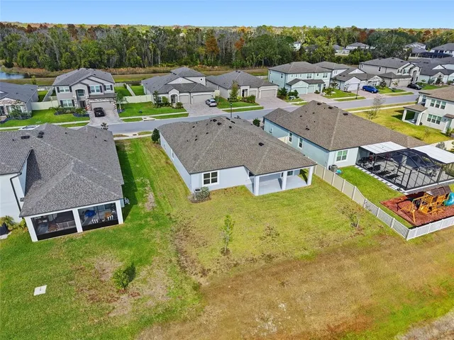 an aerial view of a house with pool and trees