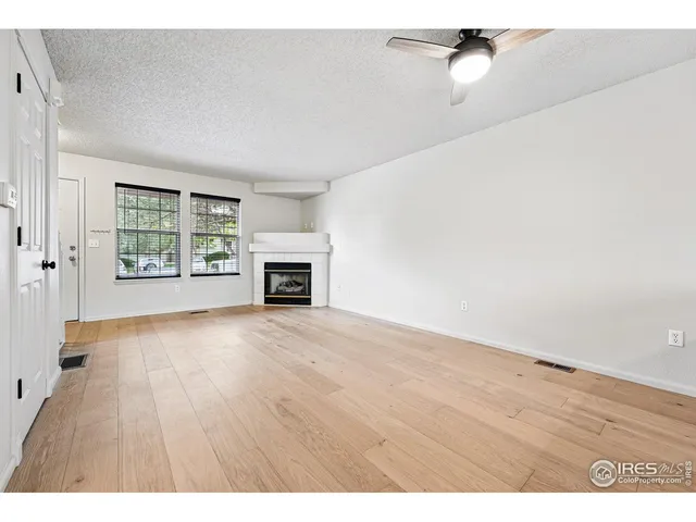 a view of empty room with a fireplace and wooden floor