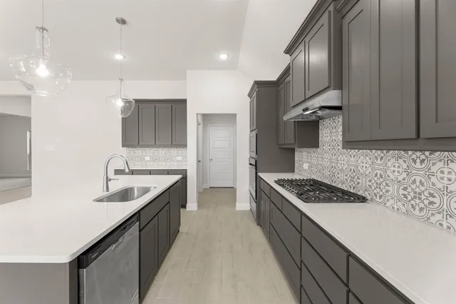 a large kitchen with kitchen island a sink stainless steel appliances and cabinets