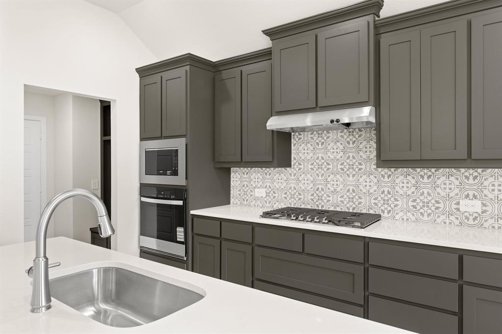 1007 Sedona Trail Justin, TX 76247 - Photo 12 of 40 a kitchen with stainless steel appliances granite countertop a sink a stove and refrigerator