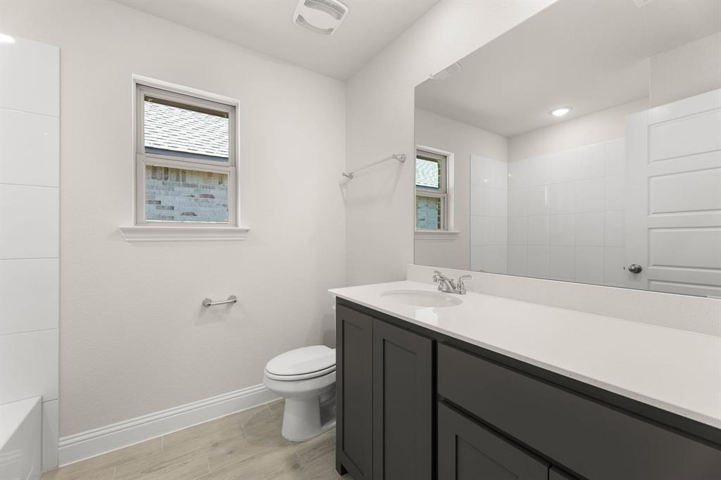 1007 Sedona Trail Justin, TX 76247 - Photo 13 of 40 a bathroom with a sink a toilet and mirror