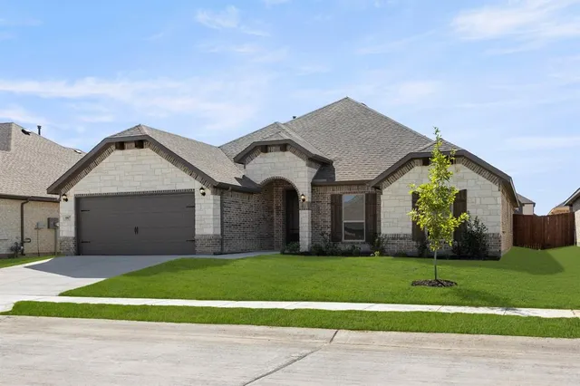 a view of a house with a big yard and large trees