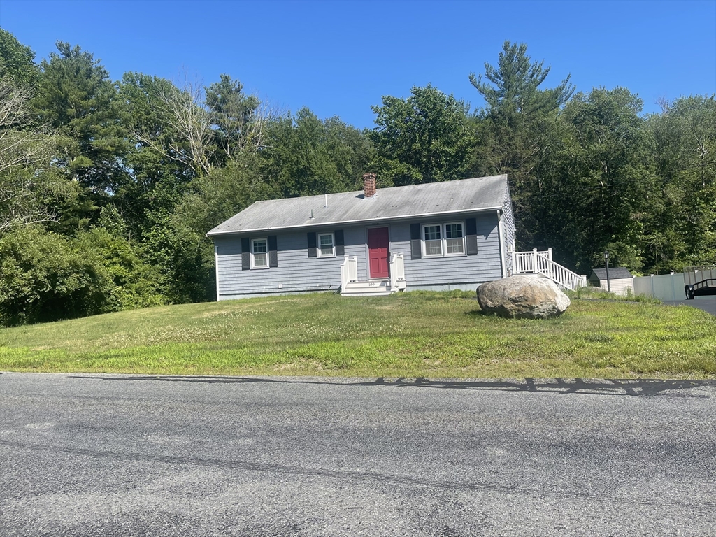 a front view of a house with a yard and trees