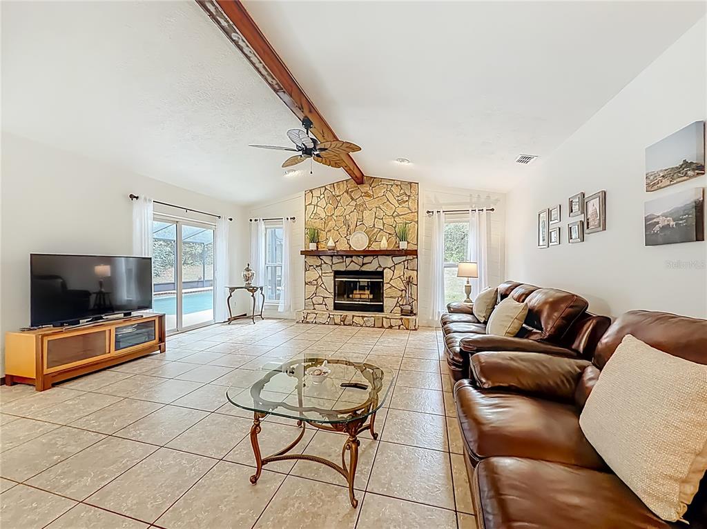 4353 North Indianhead Road Hernando, FL 34442 - Photo 12 of 65 a living room with furniture a flat screen tv and a fireplace