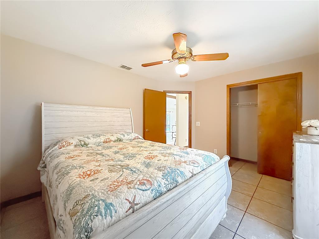 4353 North Indianhead Road Hernando, FL 34442 - Photo 32 of 65 a large bed sitting in a bedroom next to a window and a chandelier