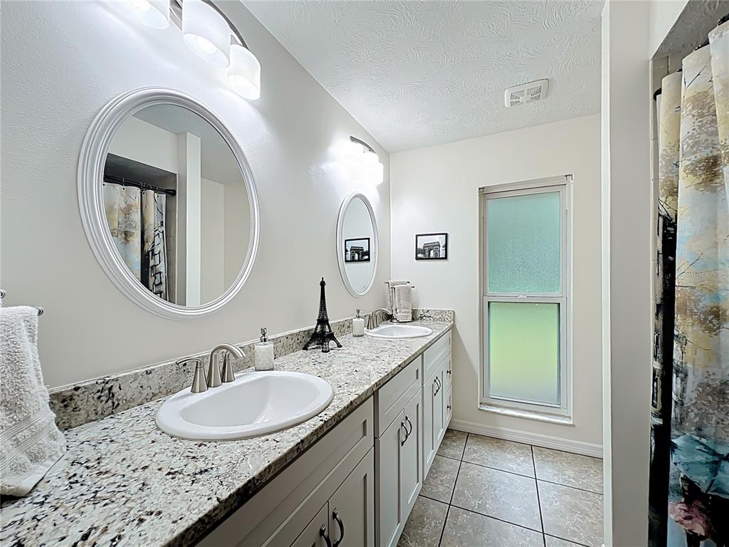 4353 North Indianhead Road Hernando, FL 34442 - Photo 34 of 65 a bathroom with a granite countertop double vanity sink and a mirror