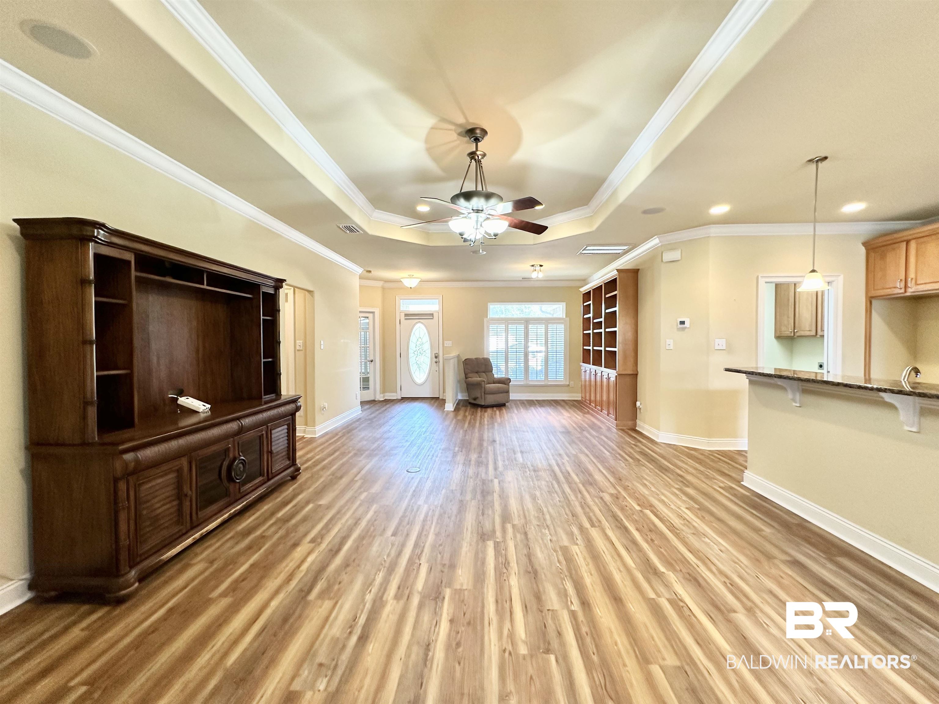 249 Hemingway Loop Foley, AL 36535 - Photo 4 of 33 Unfurnished living room featuring crown molding, ceiling fan, light wood-type flooring, and a raised ceiling