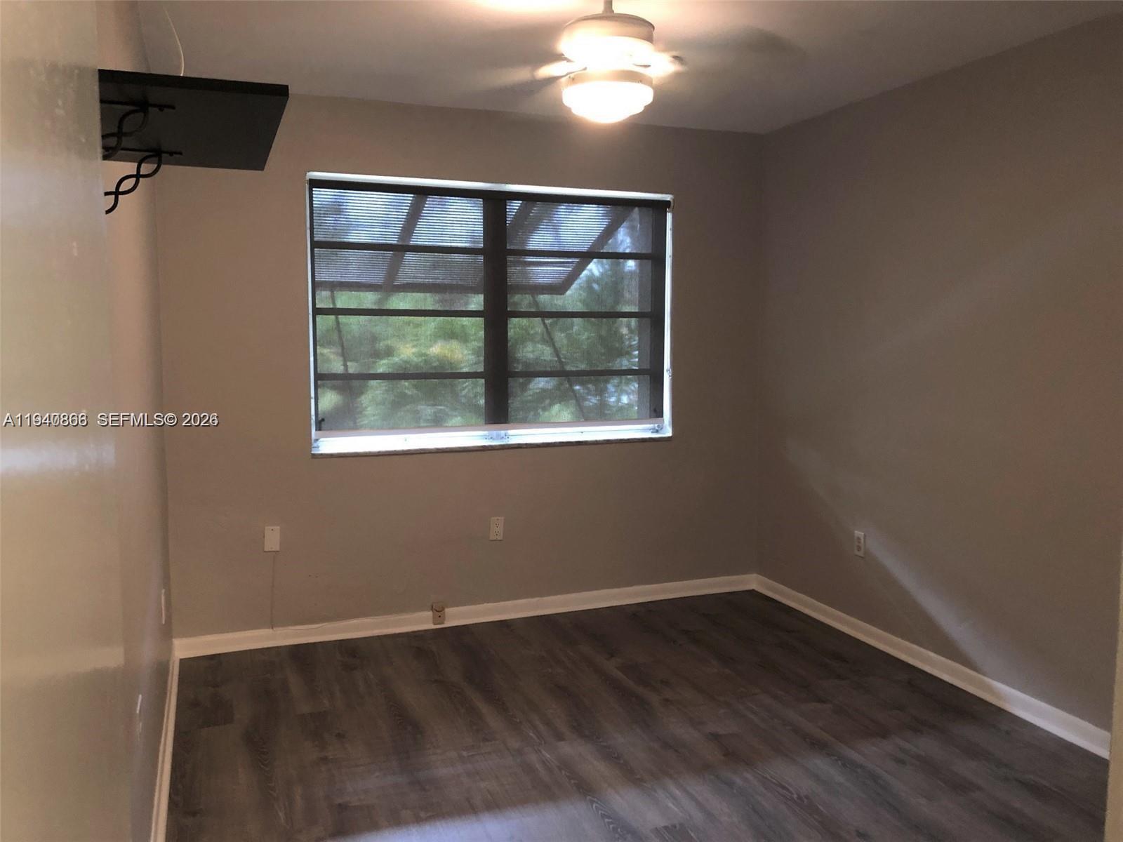 9350 Southwest 77th Avenue, Unit G8 Miami, FL 33156 - Photo 5 of 11 an empty room with wooden floor and windows