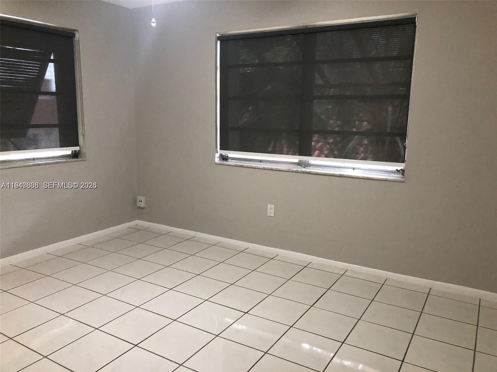 9350 Southwest 77th Avenue, Unit G8 Miami, FL 33156 - Photo 8 of 11 a view of an empty room with window