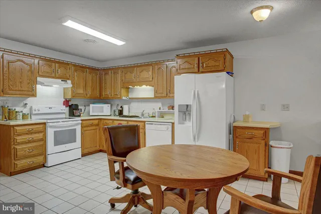 a kitchen with a refrigerator a stove a sink dishwasher and wooden cabinets with wooden floor