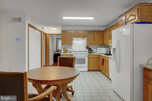 a kitchen with a refrigerator a stove a sink dishwasher and white cabinets with wooden floor