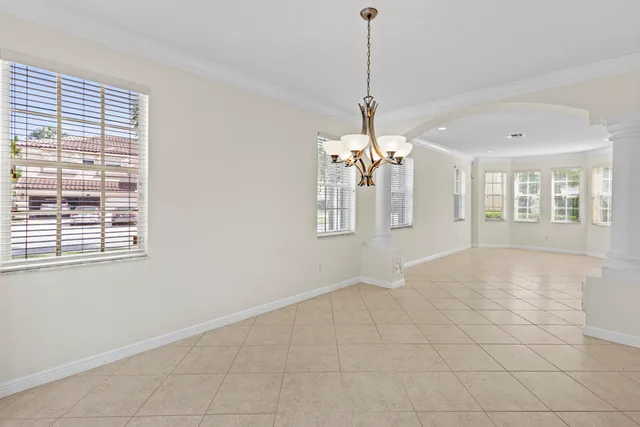 an empty room that has a window and a chandelier