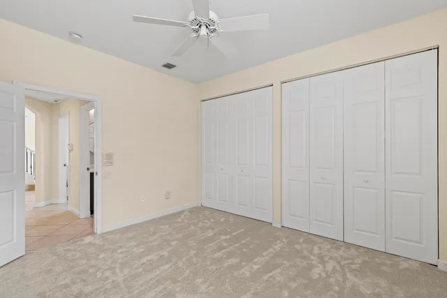 a view of empty room with wooden floor and ceiling fan