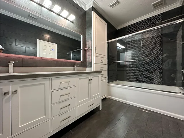 a spacious bathroom with a double vanity sink a mirror and a bathtub