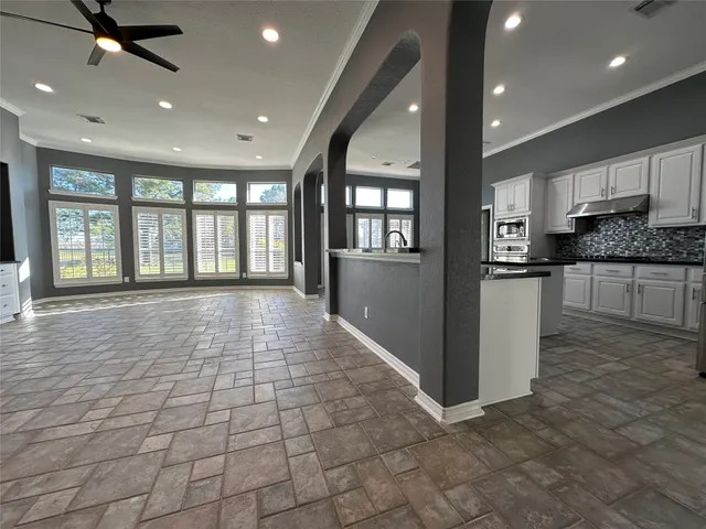 a open kitchen with stainless steel appliances granite countertop a refrigerator and a stove top oven