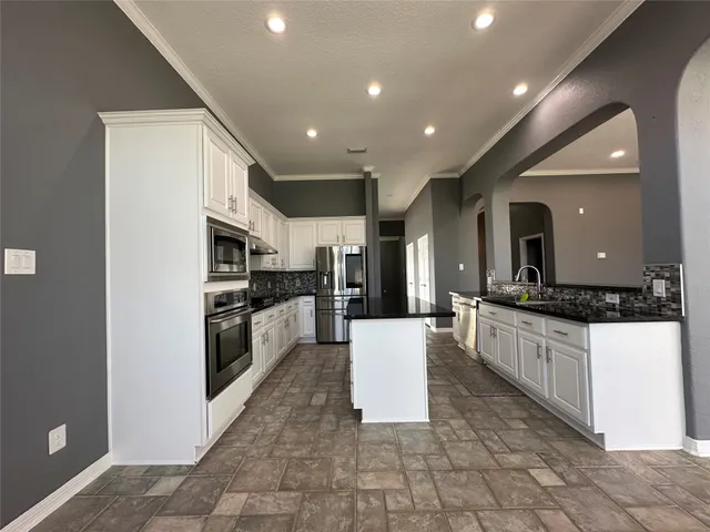 a large kitchen with stainless steel appliances a refrigerator and a stove top oven