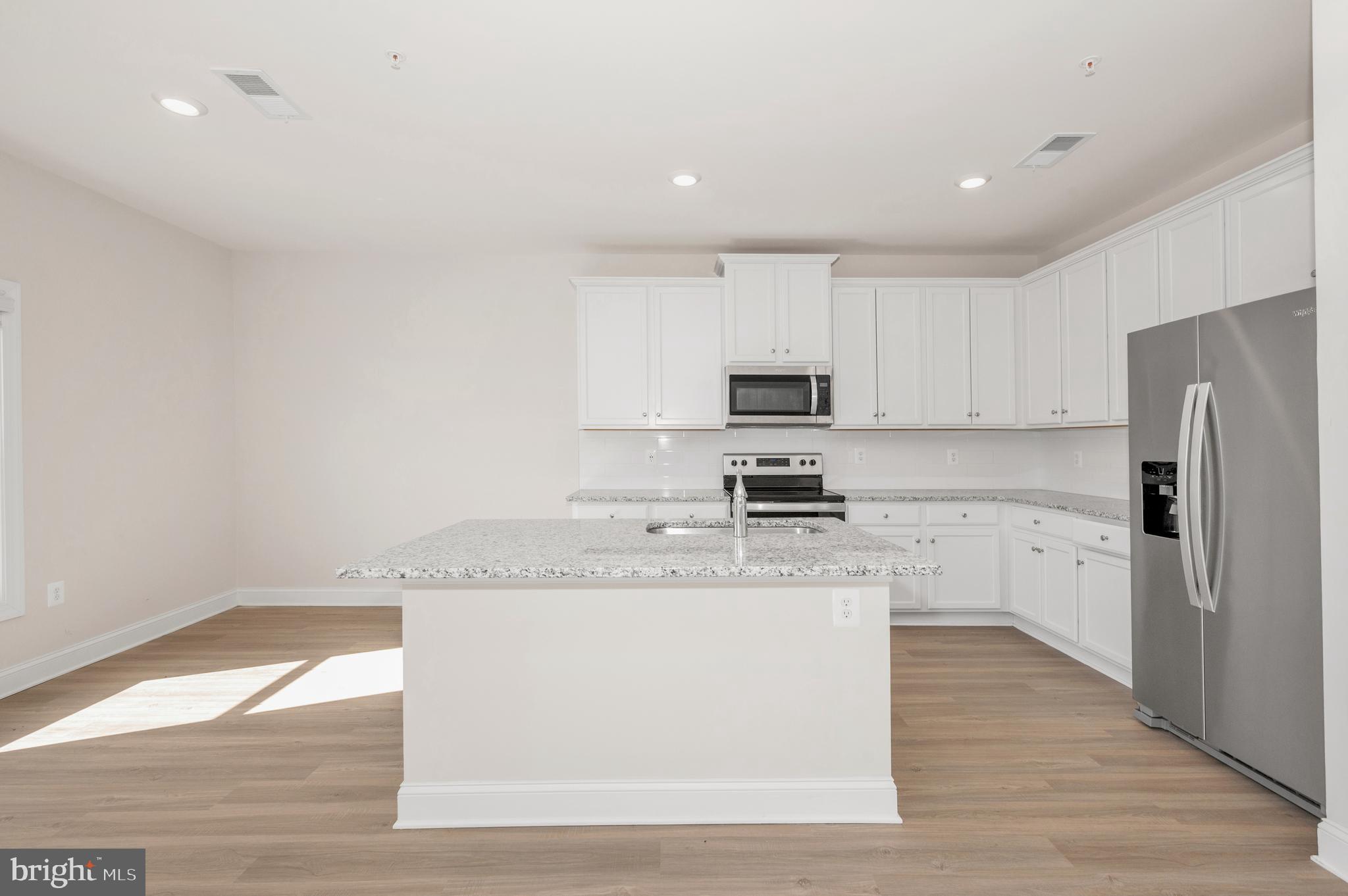 9962 Roulette Drive Hagerstown, MD 21740 - Photo 13 of 43 a kitchen with stainless steel appliances granite countertop a sink a stove a refrigerator and white cabinets