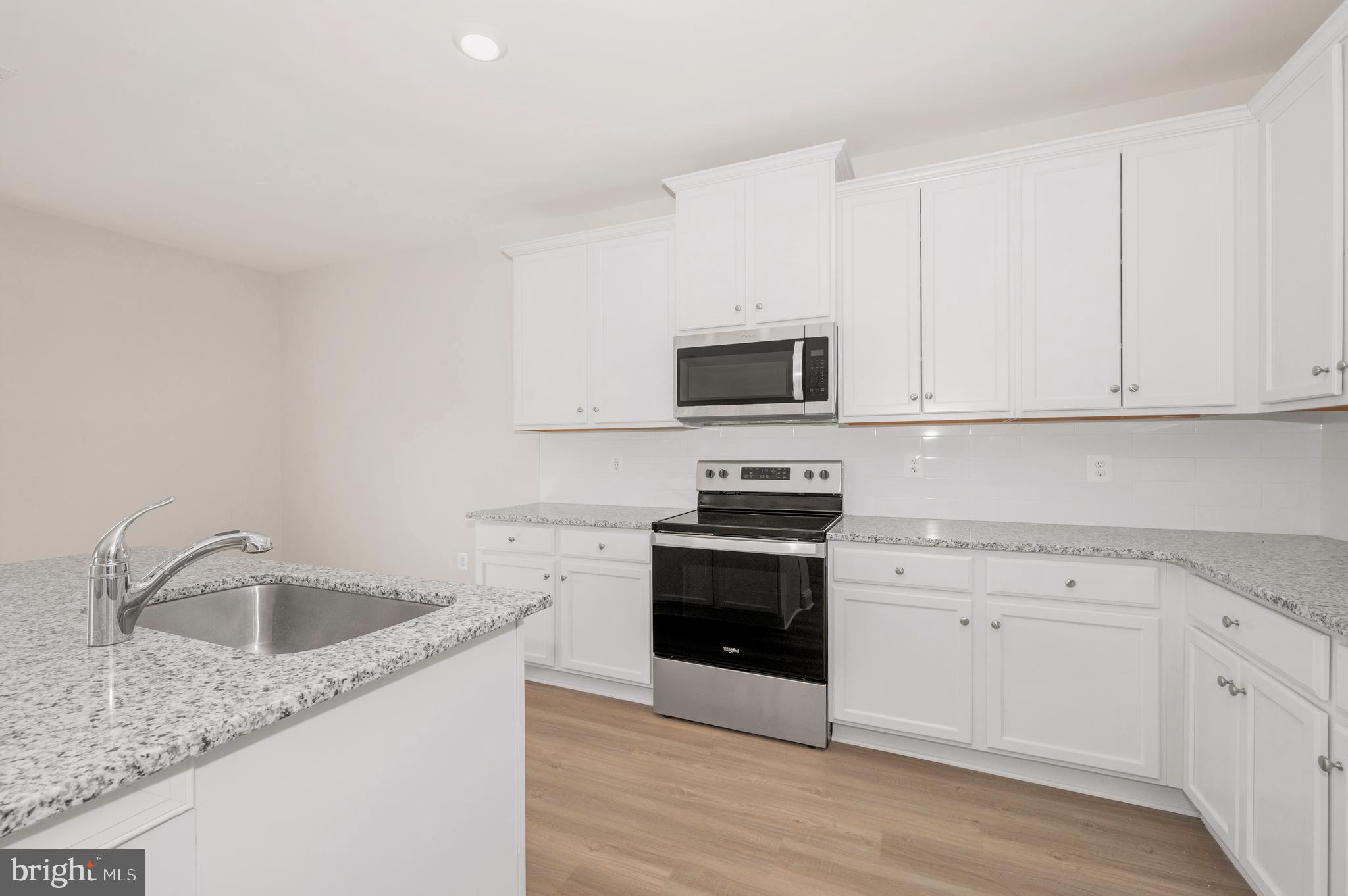 9962 Roulette Drive Hagerstown, MD 21740 - Photo 14 of 43 a kitchen with stainless steel appliances granite countertop a sink a stove a microwave and cabinets