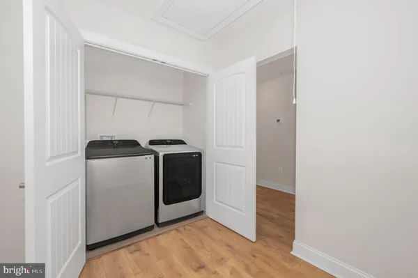 a utility room with wooden floor washer and dryer