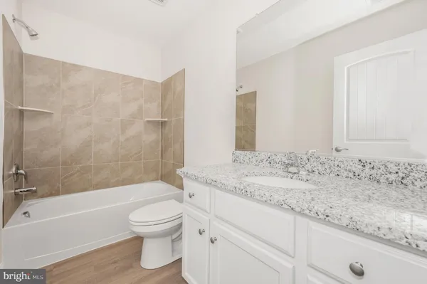 a bathroom with a granite countertop toilet a sink and bathtub