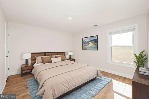 a bedroom with bed and a potted plant on dresser