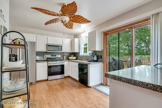 a kitchen with stainless steel appliances granite countertop a stove a sink and a refrigerator