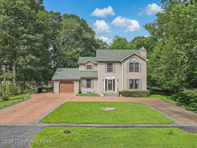 a front view of a house with a garden and plants