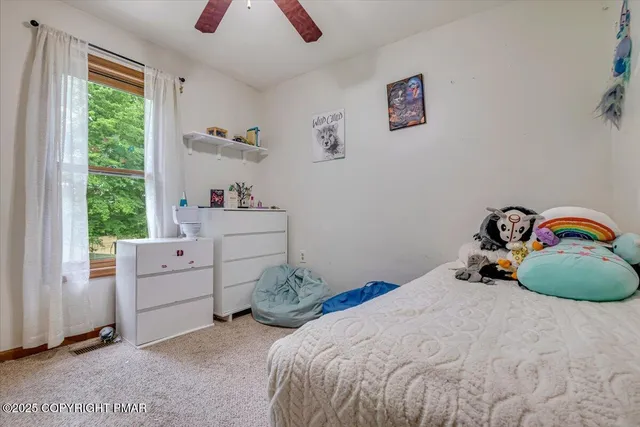 a view of a patio with table and chairs under an umbrella with wooden floor and fence