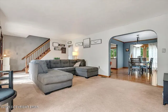a living room with furniture and a dining table