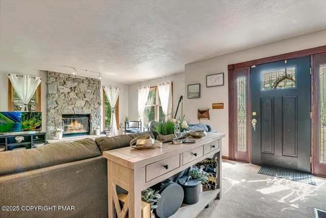 a living room with furniture fireplace and a large window