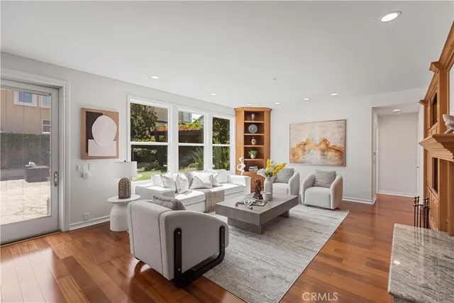 a living room with furniture large window and kitchen view