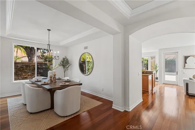 a view of a dining room with furniture a chandelier and wooden floor