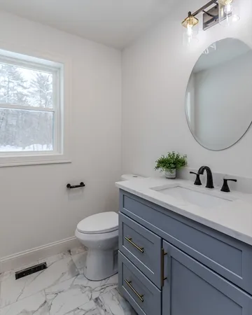 a bathroom with a granite countertop toilet sink and mirror