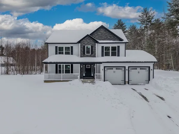 a front view of a house with yard and parking