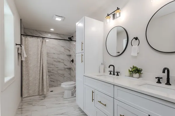 a bathroom with a granite countertop sink a toilet and a mirror