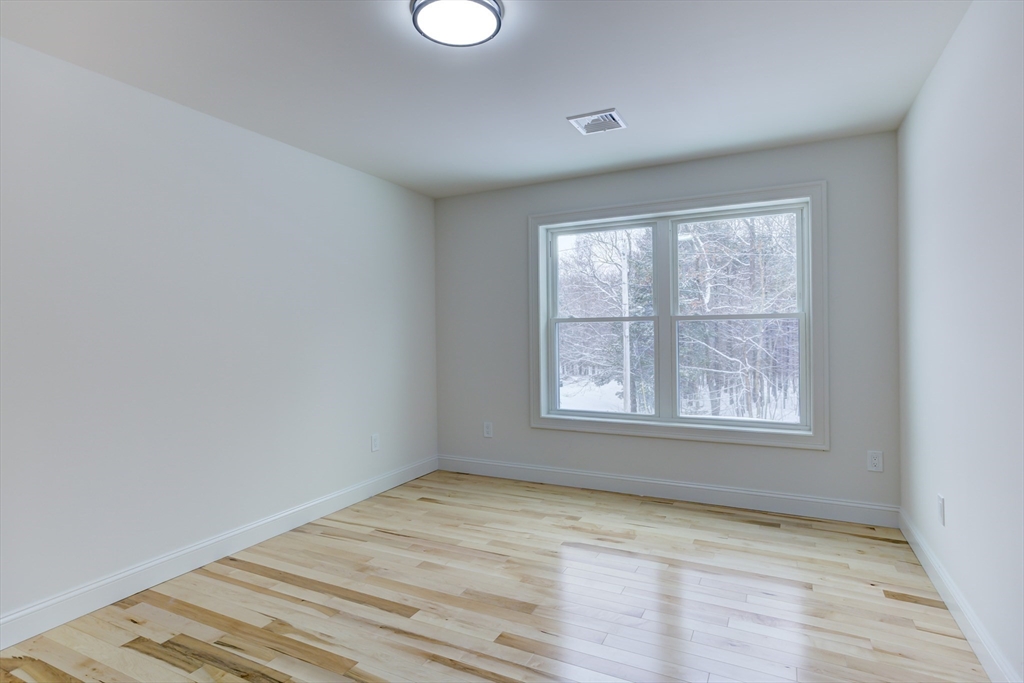 6 Winslow Road Ware, MA 01082 - Photo 23 of 35 an empty room with wooden floor and windows