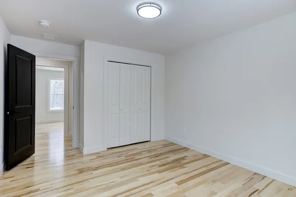 an empty room with wooden floor and closet