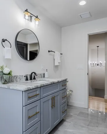 a bathroom with a granite countertop sink and a mirror