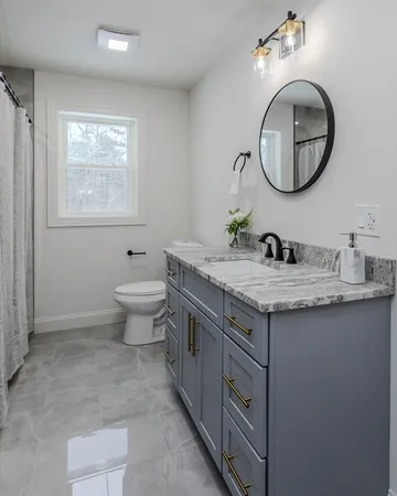 a bathroom with a granite countertop toilet a sink and a mirror