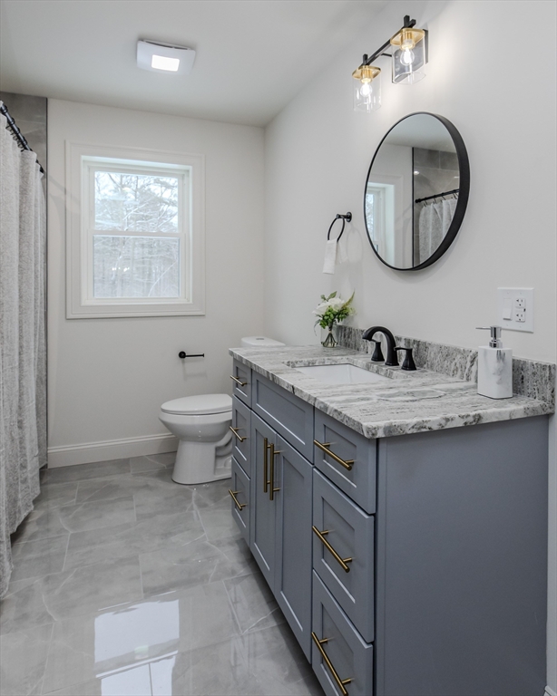 6 Winslow Road Ware, MA 01082 - Photo 28 of 34 a bathroom with a granite countertop toilet a sink and a mirror