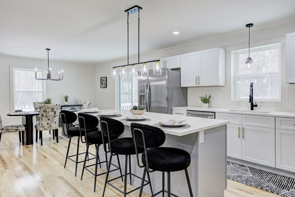6 Winslow Road Ware, MA 01082 - Photo 7 of 35 a kitchen with stainless steel appliances kitchen island granite countertop a dining table chairs and white cabinets