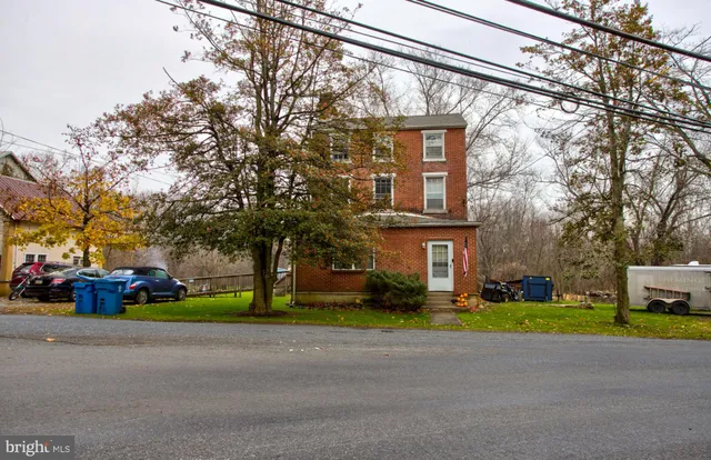 a front view of a house with a garden and trees