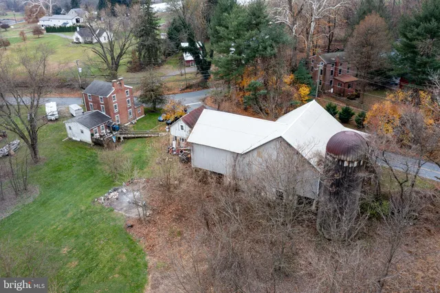 an aerial view of a house with outdoor space and trees all around