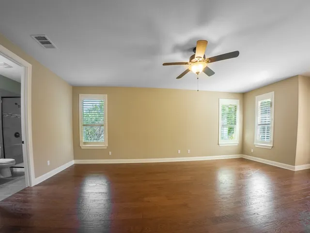 a view of a livingroom with a ceiling fan and wooden floor