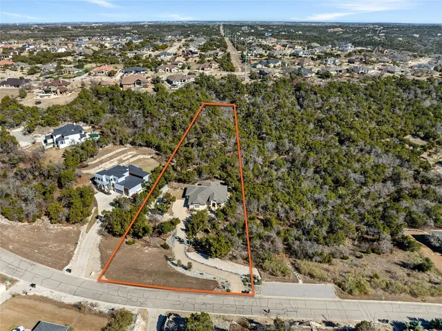 a aerial view of a house with a yard and tree s